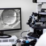 Embryologist performing ICSI, injecting sperm into an egg under a microscope in an IVF lab